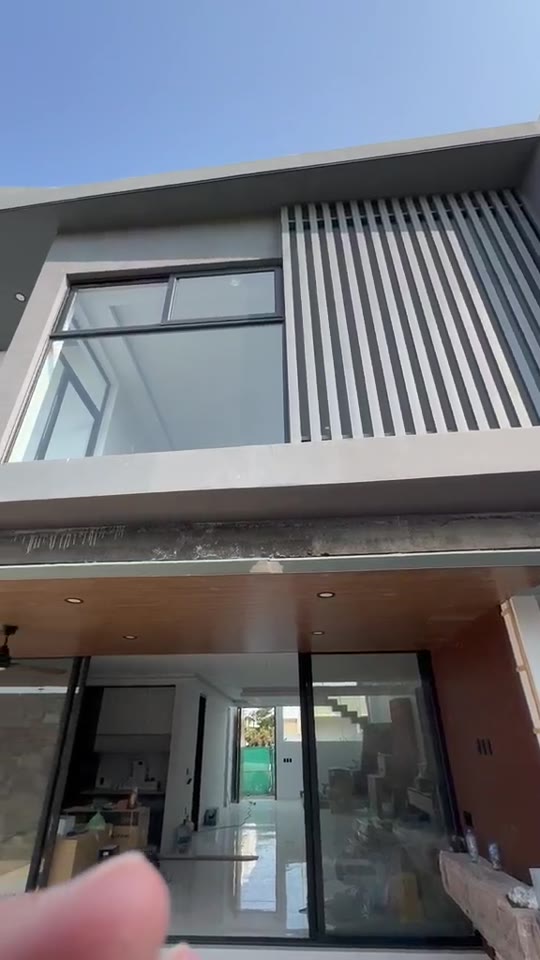 Fachada de vivienda con paneles oscuros, madera y cristal